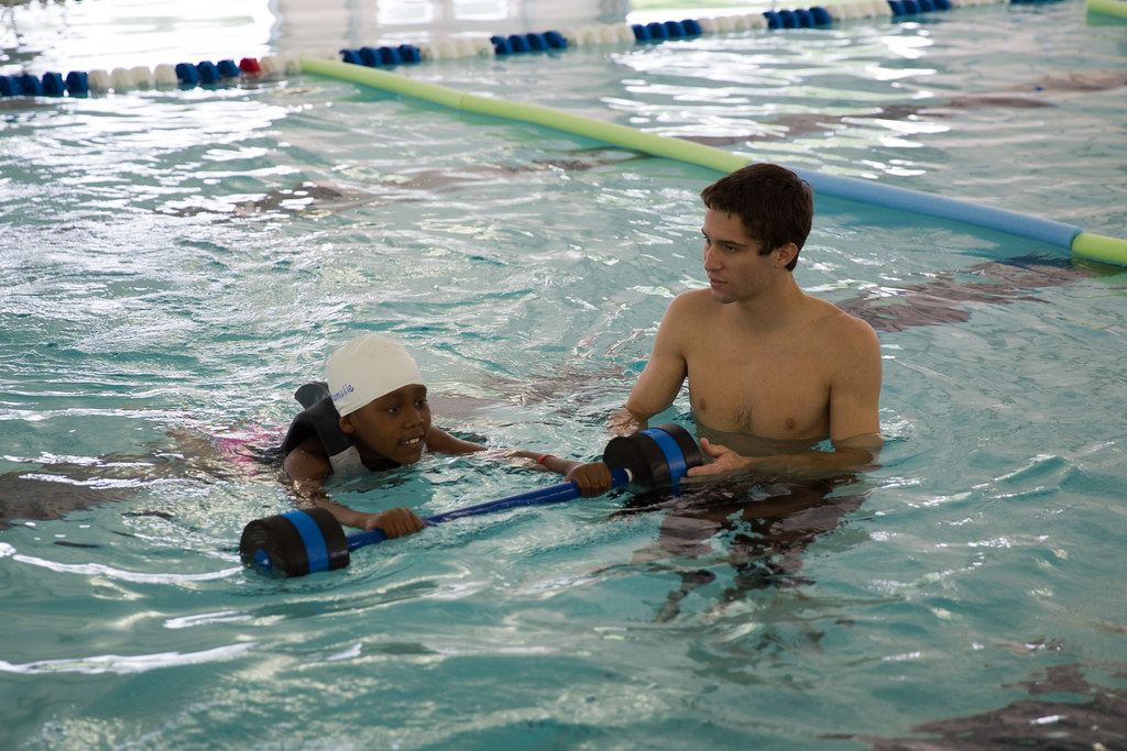 Kind leert zwemmen met een trainer